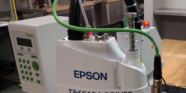 Schneider & Company - A Deprag Epson T3-SCARA driver industrial robot performing a task or demonstration on a workbench.