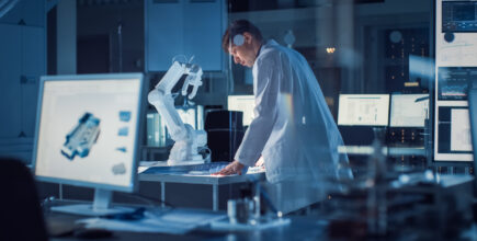 Schneider & Company - A scientist analyzing data at a high-tech workstation with a robotic arm in a modern laboratory environment during the night.