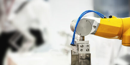 Schneider & Company - Precision at work: an industrial robot arm performing a delicate task in a modern manufacturing setting.