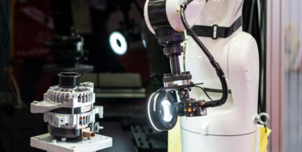 Schneider & Company - Robotic arm performing a precision inspection of machinery parts with a vision system in a high-tech manufacturing environment.